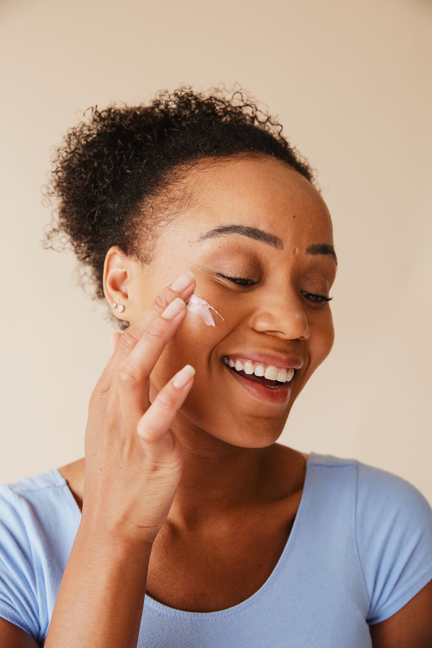 woman-putting-on-facial-cream